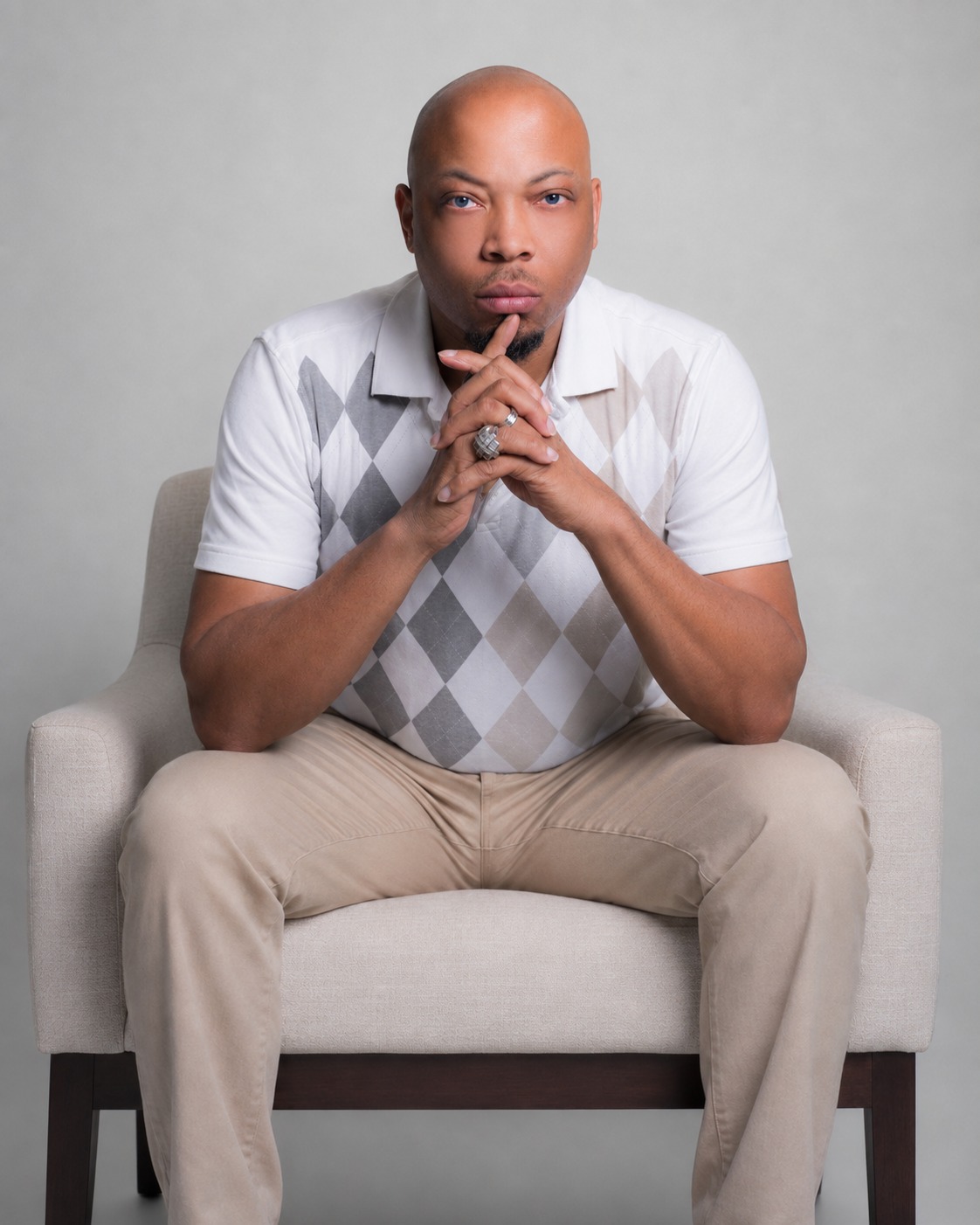 J Hackett seated in a chair, hands together, creator of the Salary Replacement Day system